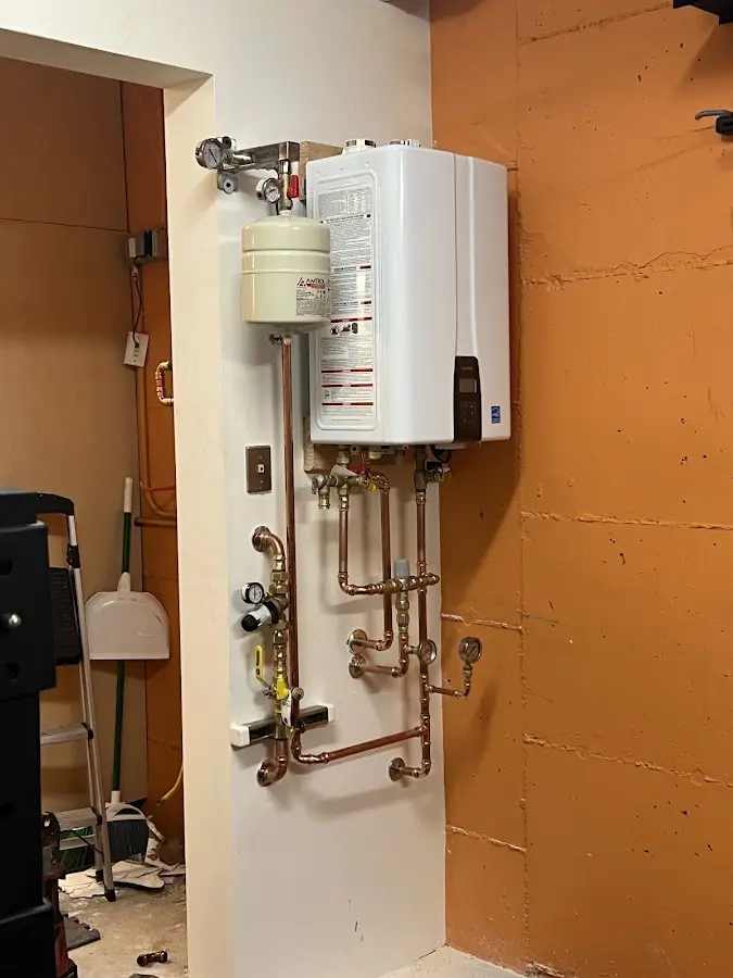 Plumbing technician inspecting water heater connections in Sun City